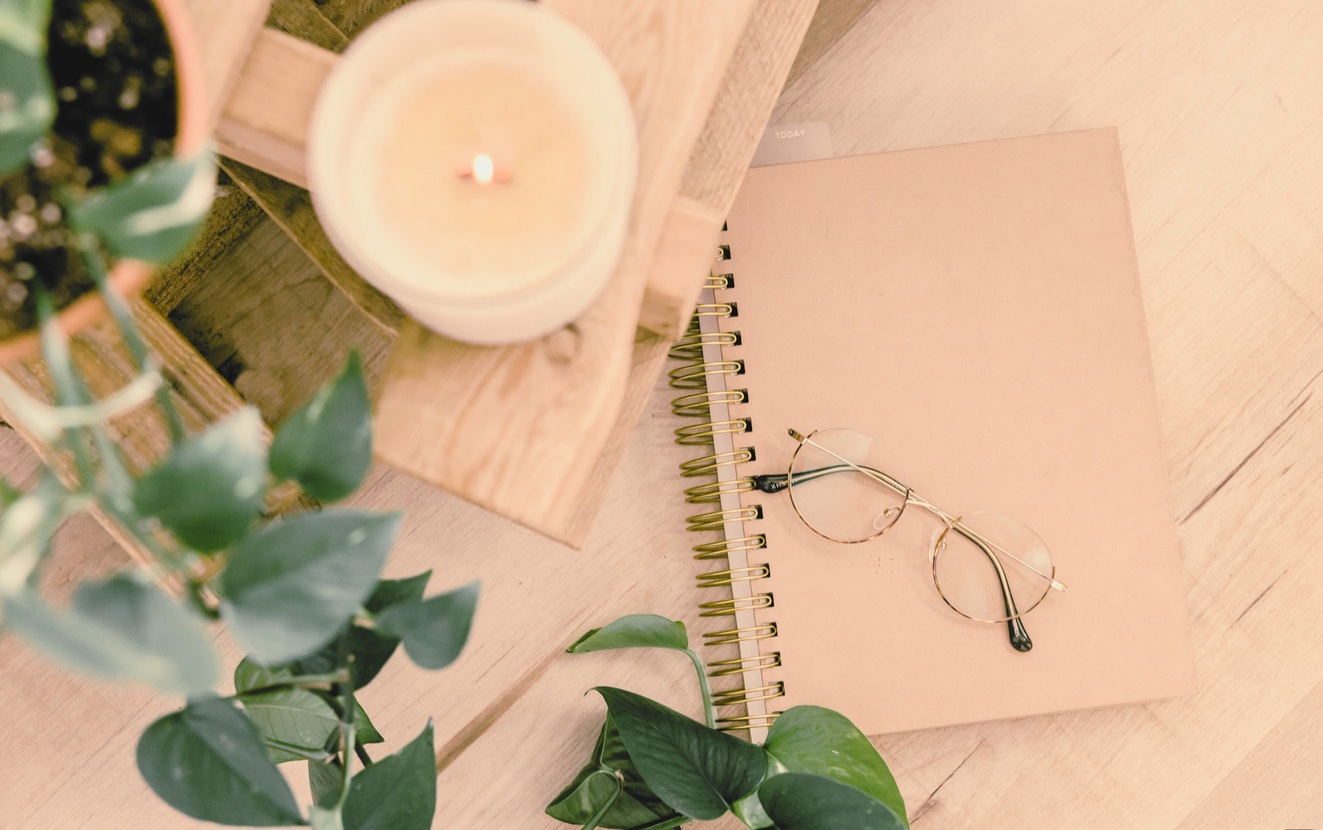 Notebook and candle on a desk with decorative vines