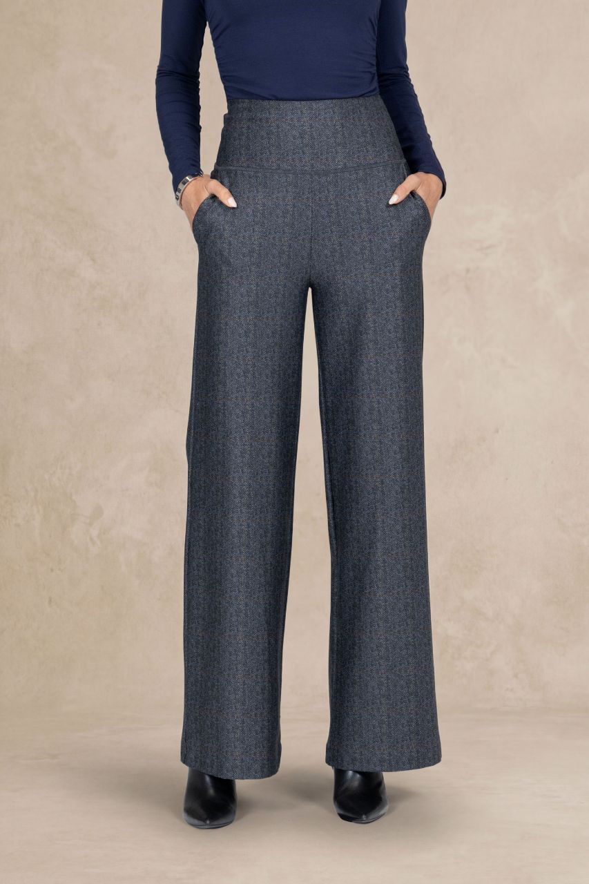 Person wearing gray tartan wide-leg pants with a beige background