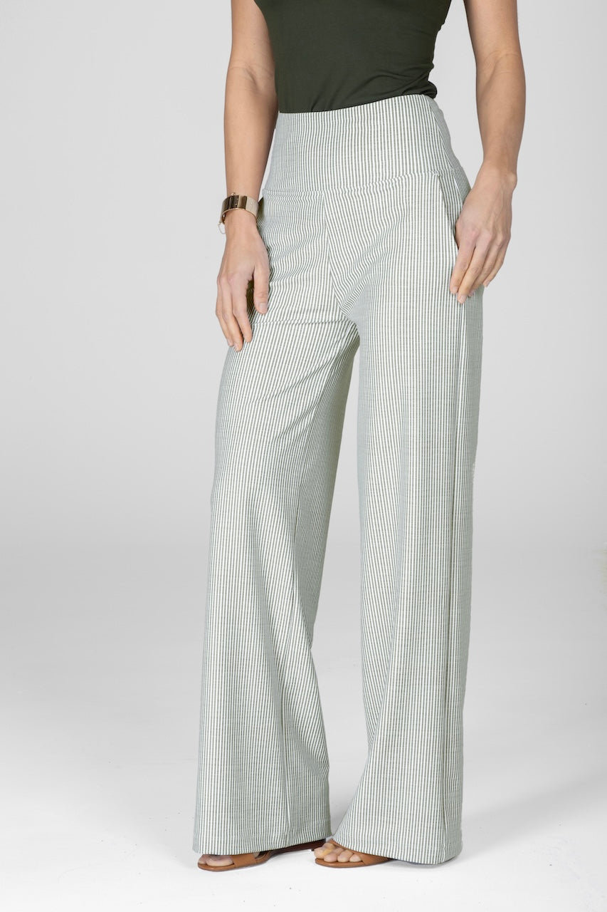 A woman standing wearing olive stripe wide-leg pants with a high waist.