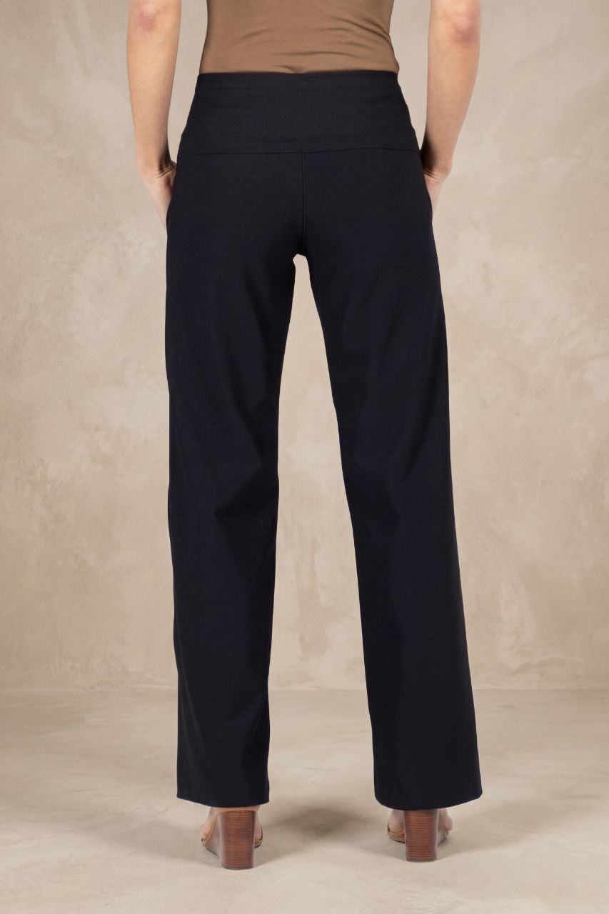 Back view of a person wearing black pants with a plain background