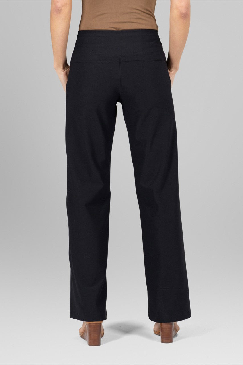 Person wearing black pants against a gray background