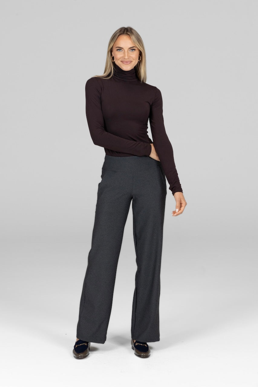 Woman wearing a brown turtleneck and gray wide leg pants