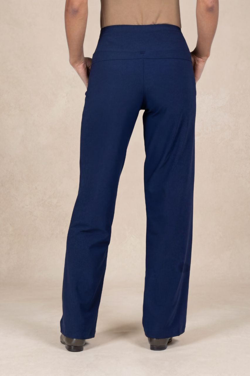 Back view of a person wearing blue pants on a beige background