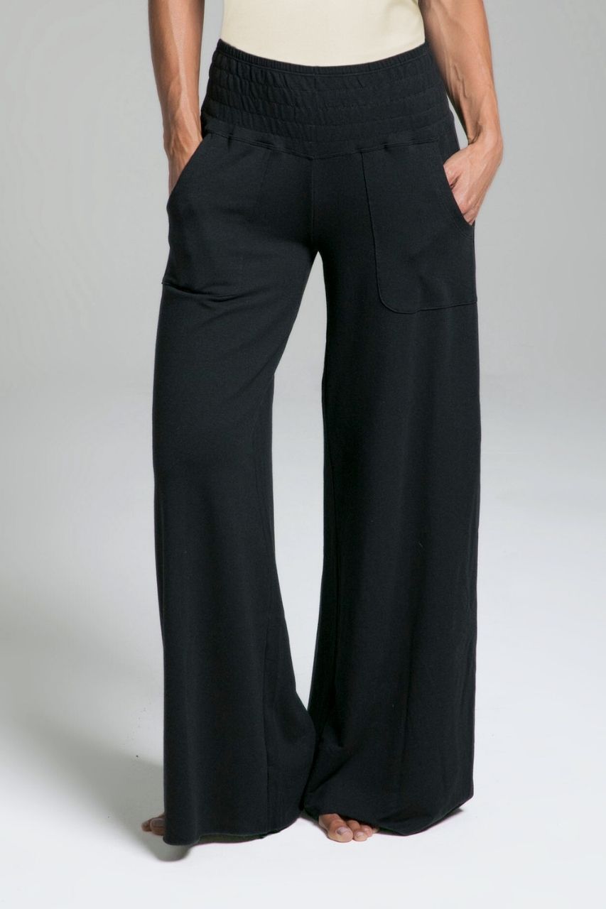 Black wide-leg lounge pants worn by a woman on a plain background