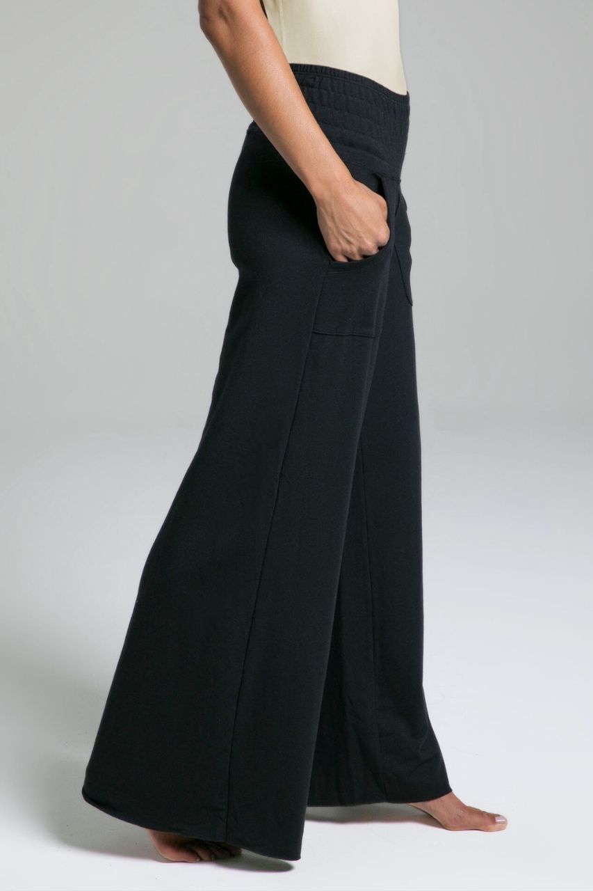 Person wearing black wide-leg lounge pants on a plain background