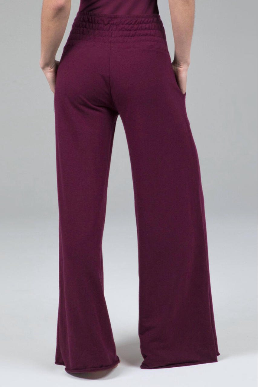 Burgundy pants worn by a woman on a white background