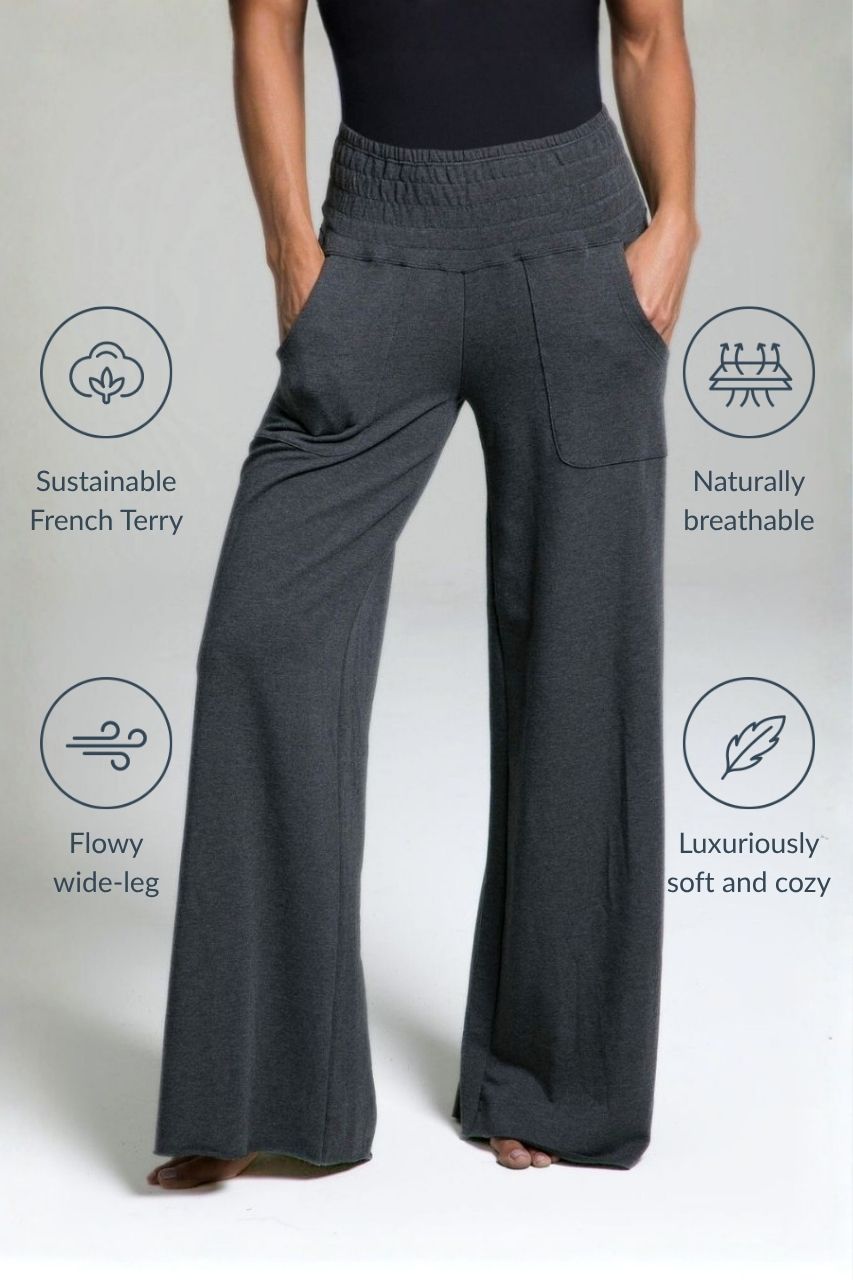 Dark gray wide-leg lounge pants worn by a woman on a light gray background with sustainability benefits listed.