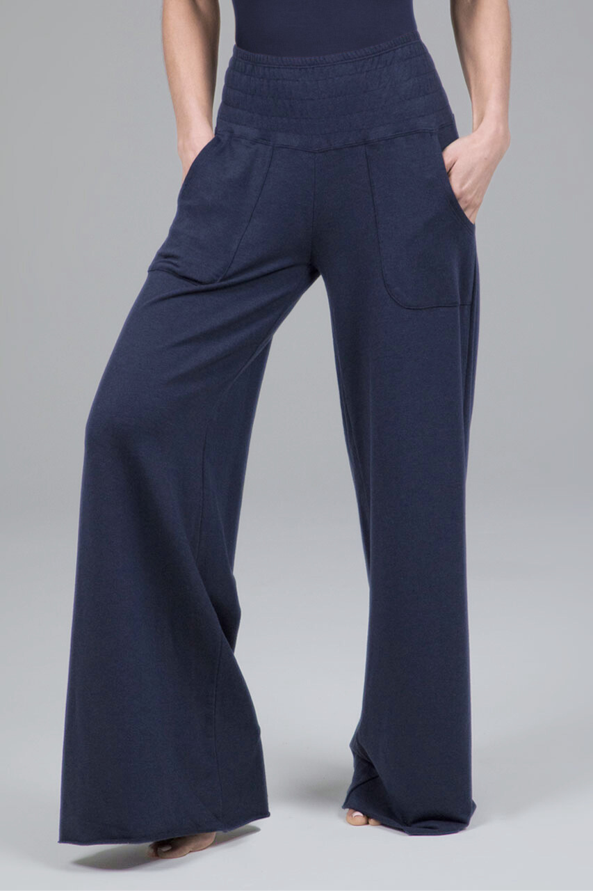 Navy blue wide-leg pants worn by a woman on a gray background