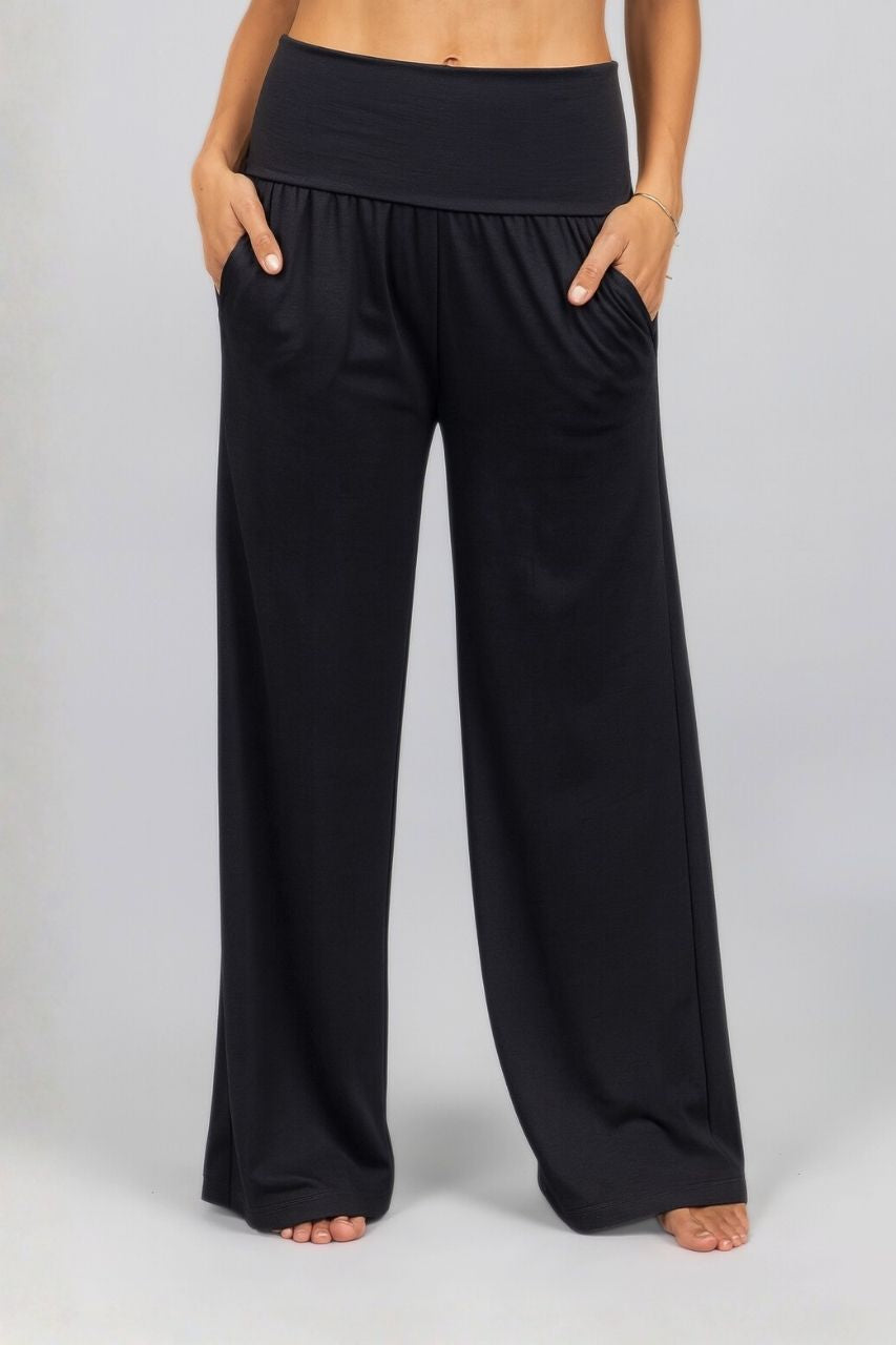 Black wide-leg palazzo pants worn by a woman on a plain background