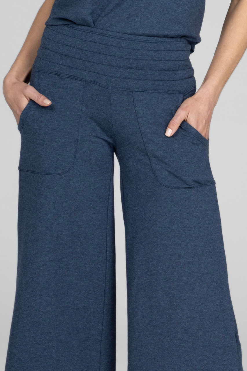 Close up view of woman wearing blue lounge pants with smocked waistband and front pockets