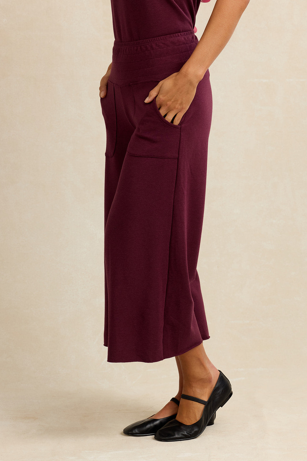 Side view of a woman wearing burgundy cropped lounge pants