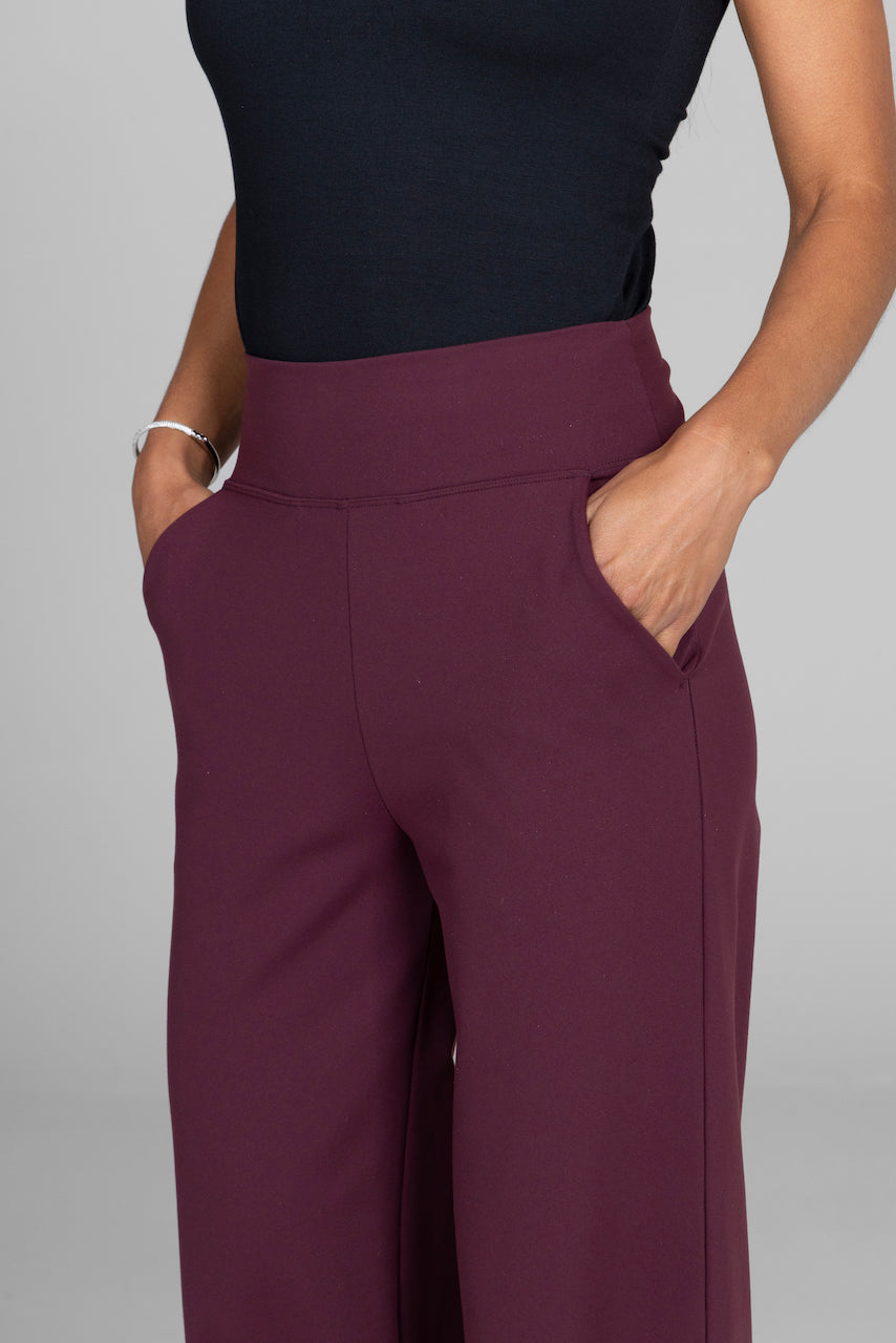 Close up view of a woman wearing burgundy wide leg pants