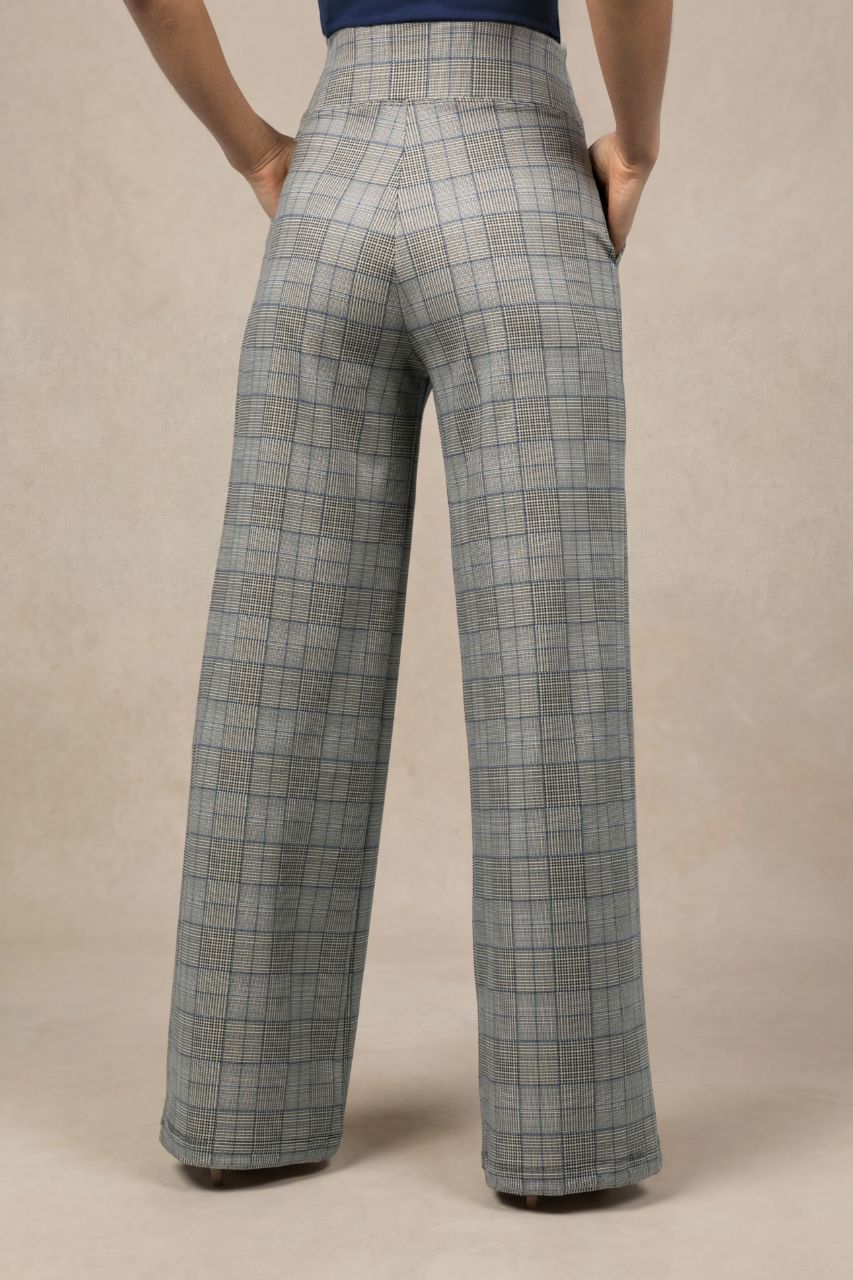Plaid wide leg pants worn by a person on a beige background
