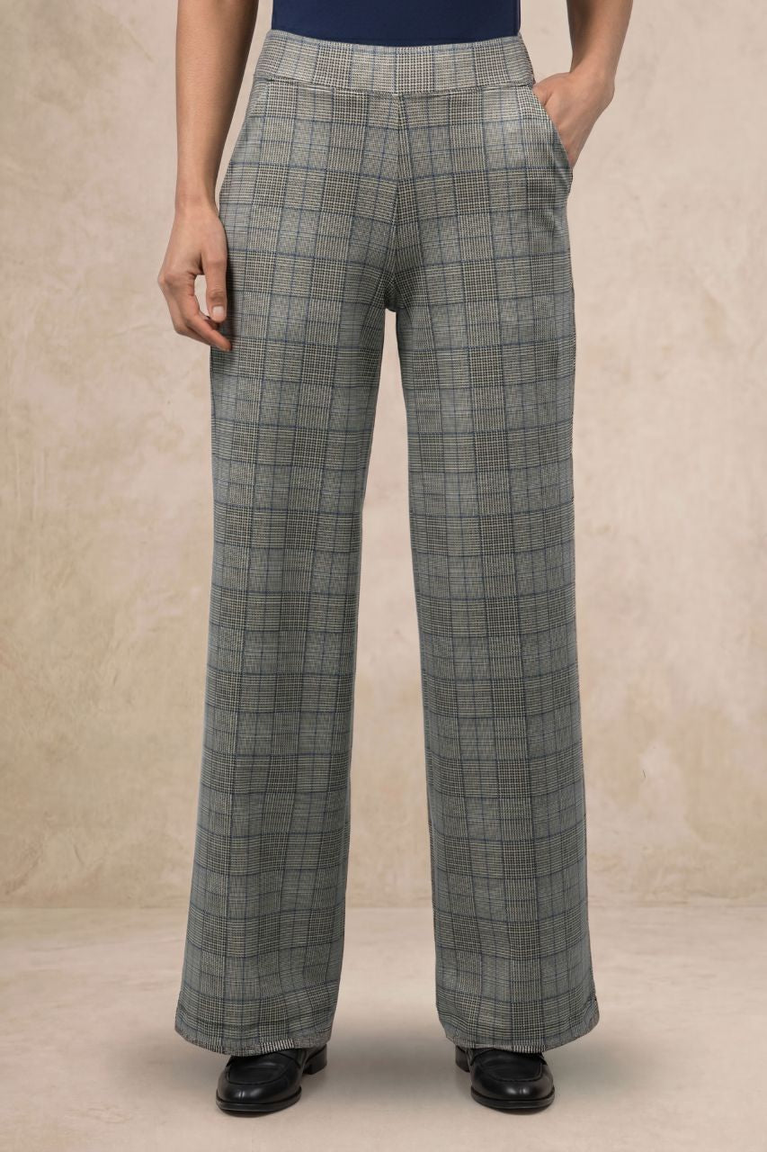 Person wearing plaid wide leg pants on a beige background