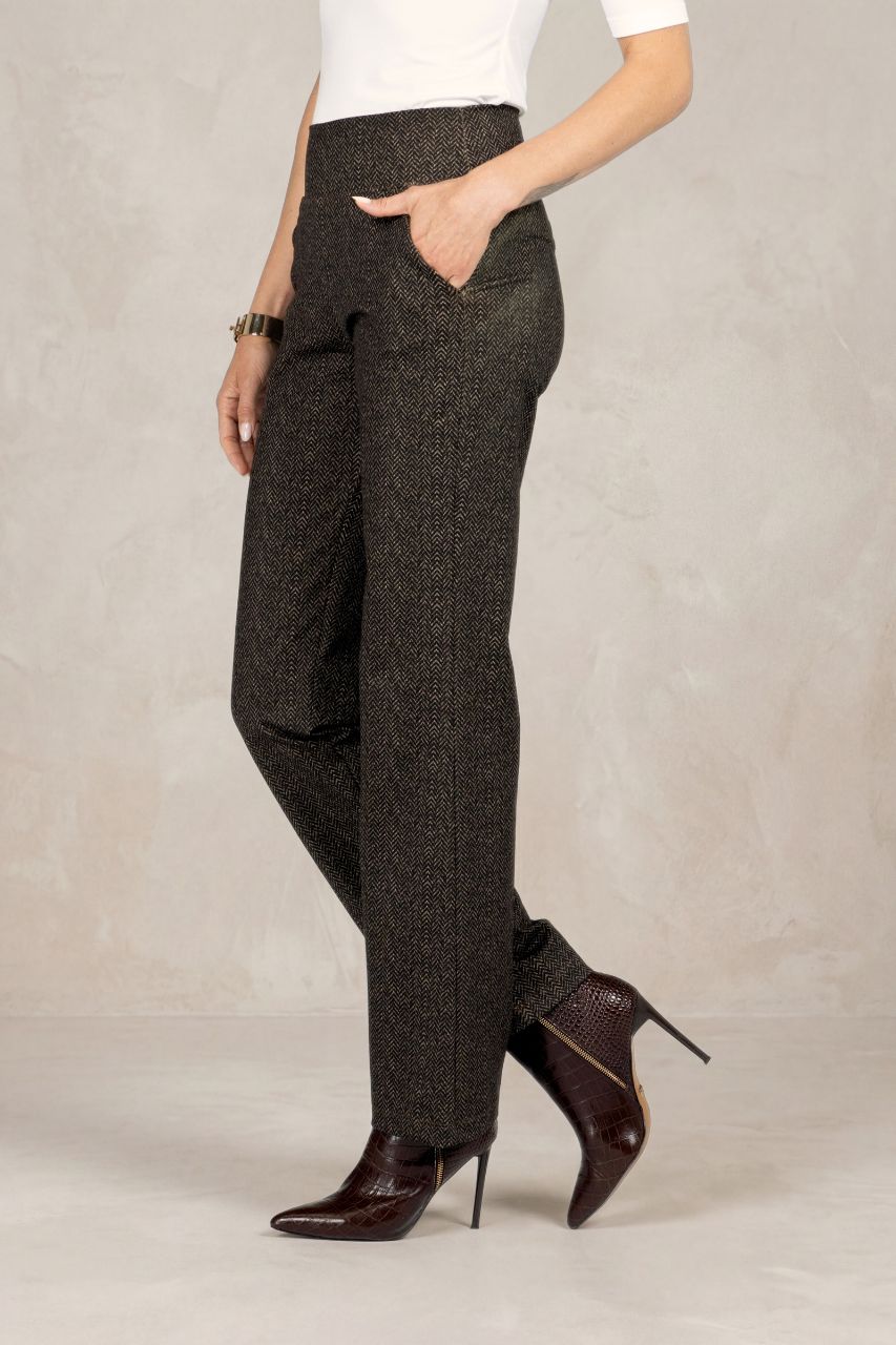 Side view of brown herringbone pants worn by a person on a neutral background