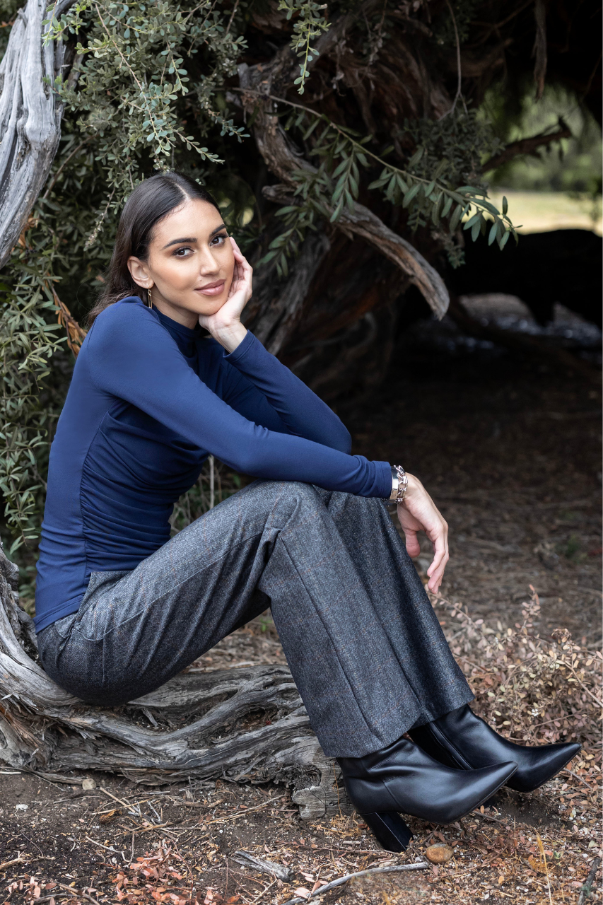 Woman sitting on a tree branch in a natural setting