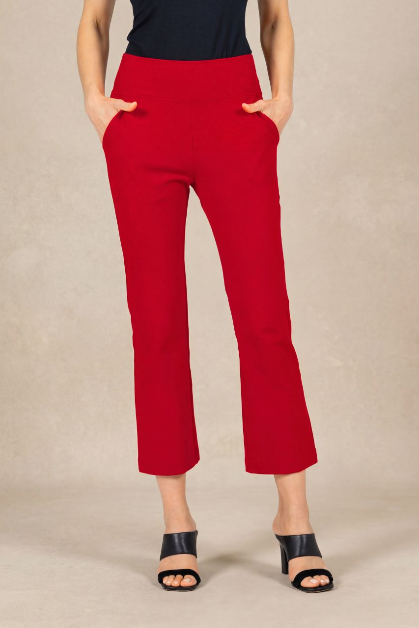 Person wearing red pants and black top on a beige background
