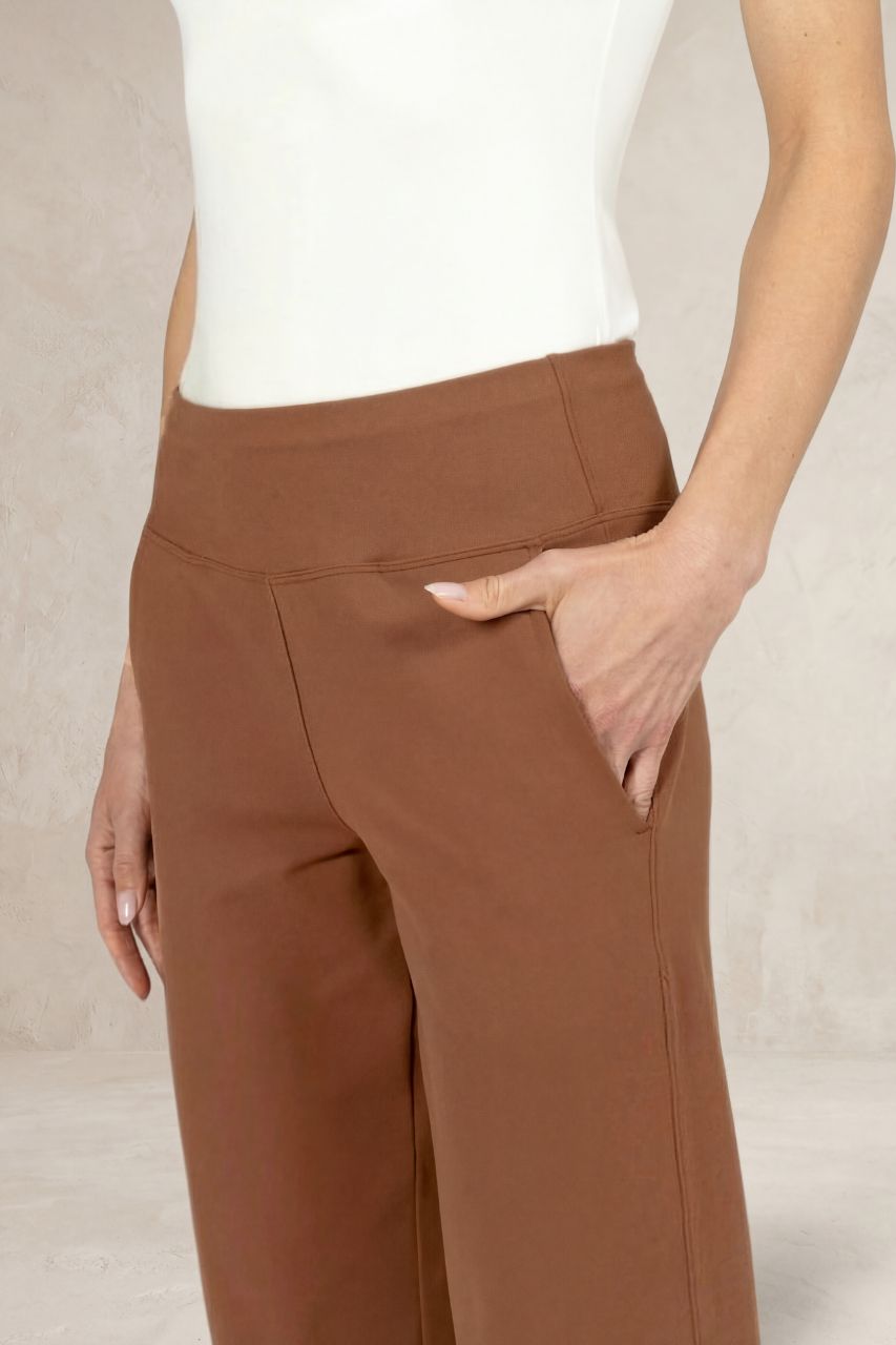 Brown pants worn by a person on a neutral background