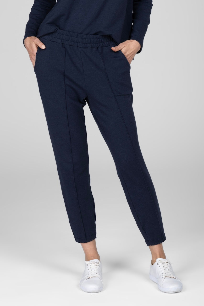 Woman wearing navy pintuck joggers with hands in pockets