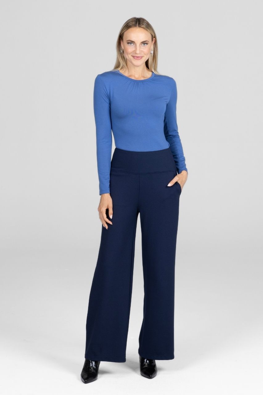 Woman wearing a blue long sleeve top with navy high waist wide leg pants
