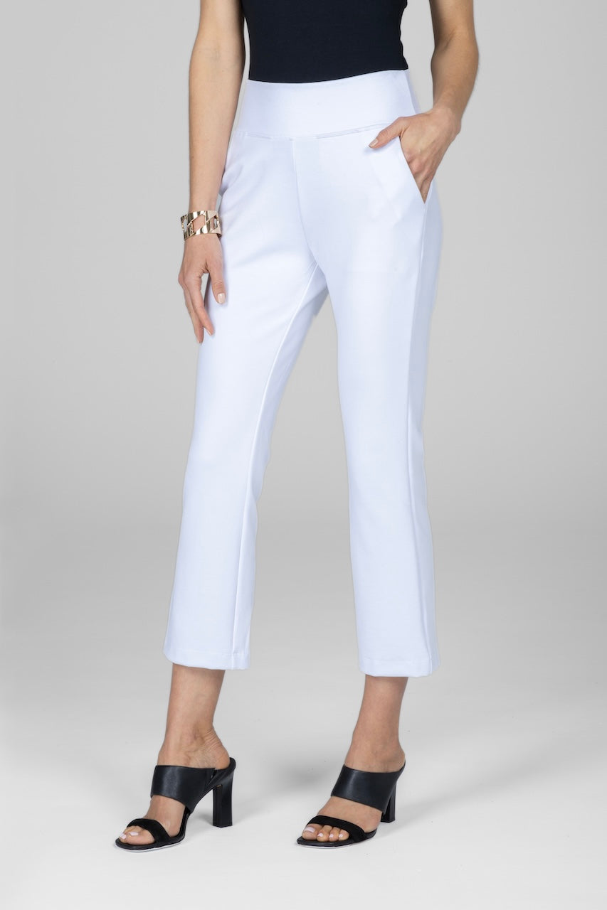 A woman wearing white high-waisted ankle pants with front pockets paired with a black top