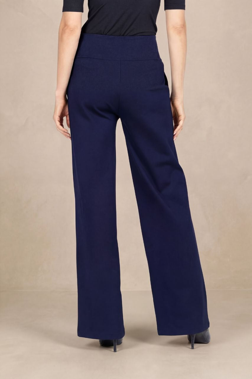 Back view of navy blue wide-leg pants worn by a person on a beige background