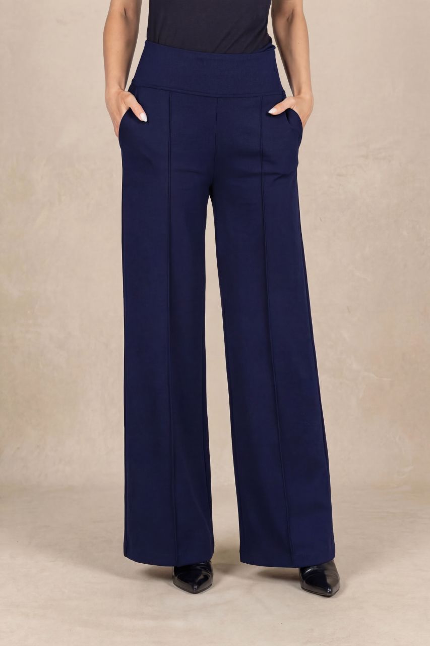 Navy blue wide-leg pants worn by a person on a beige background