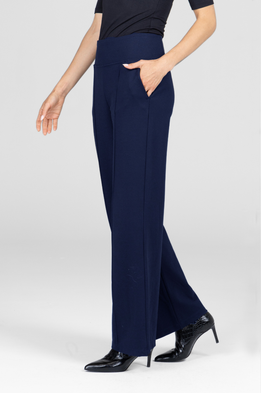 Navy blue wide leg pants worn by a woman on a white background