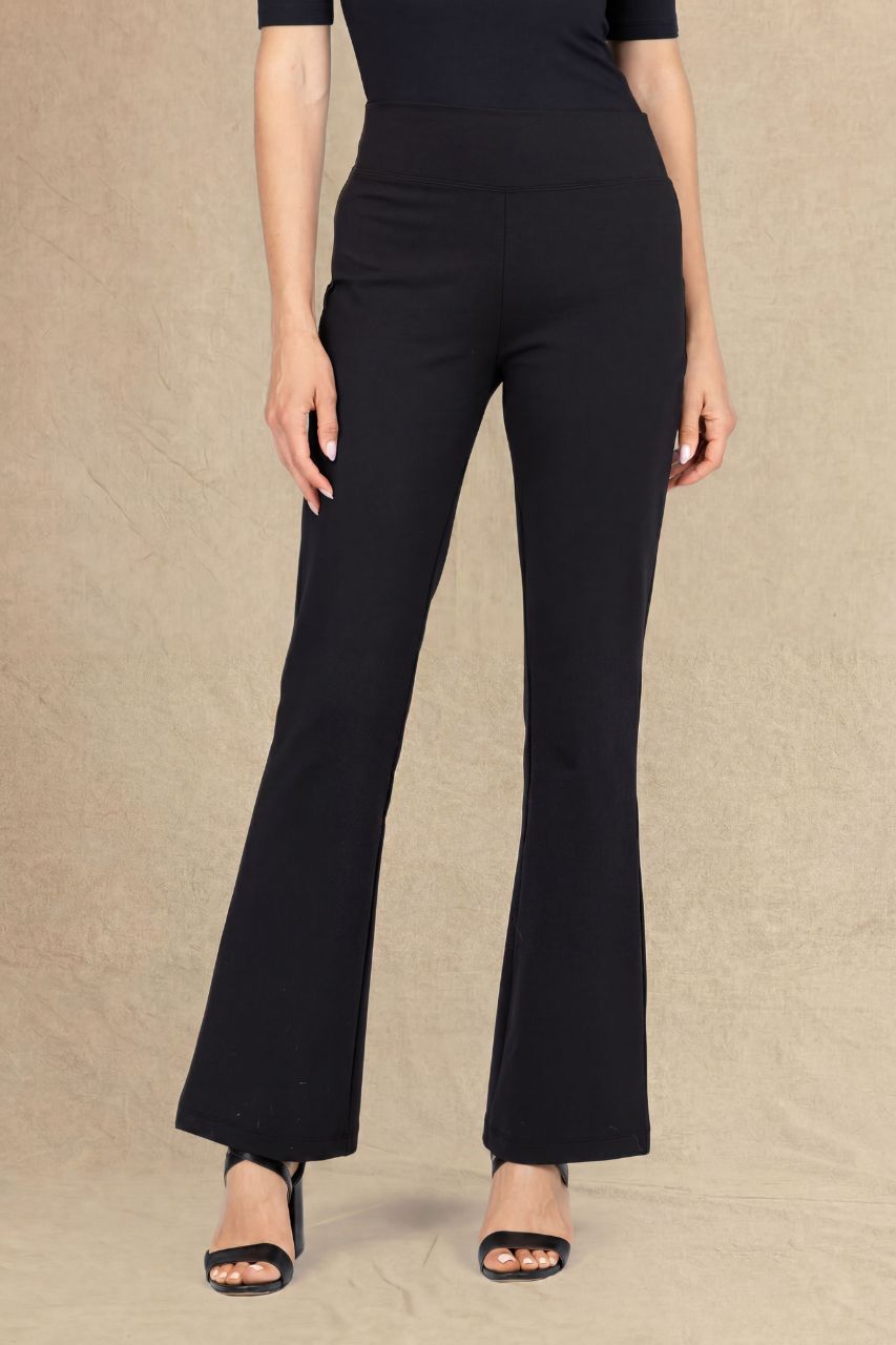 Woman wearing black micro flare pants on a beige background