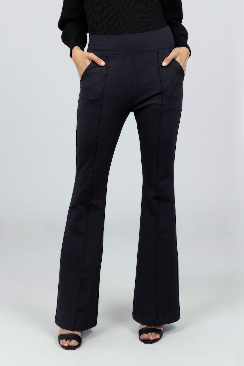 Black flared pants worn by a woman on a white background