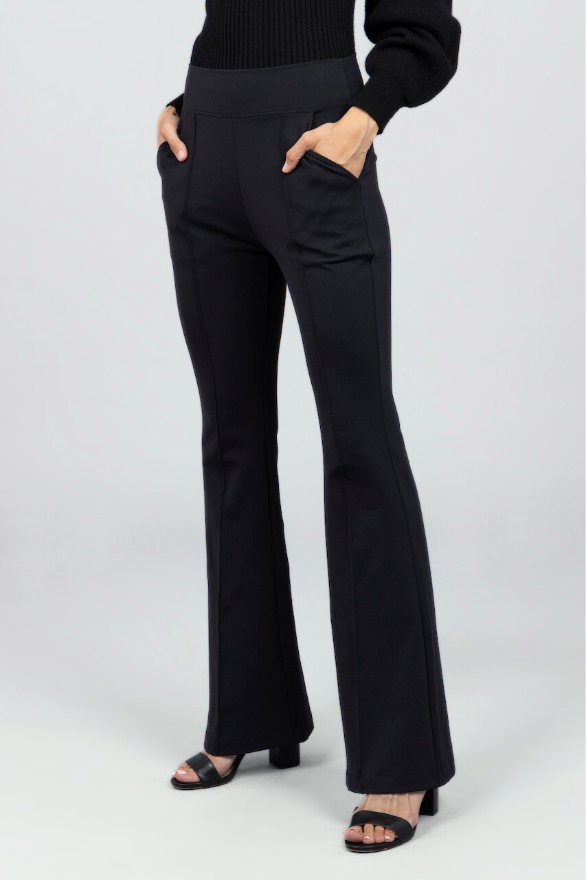 Black flared pants worn by a woman on a white background