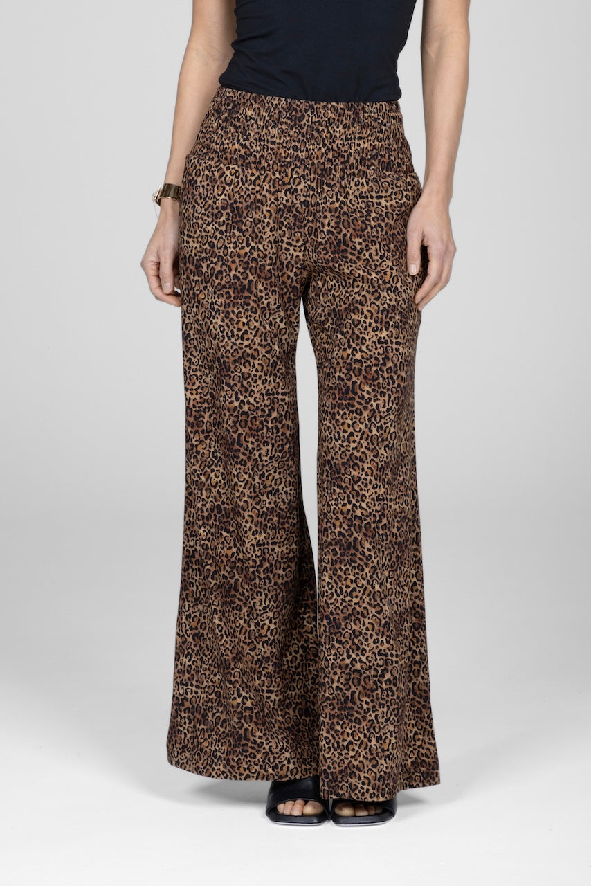 A pair of wide-leg leopard print pants with a smocked waistband and side pockets.
