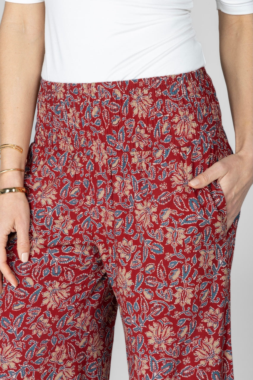 Close up of woman wearing red motif printed pants with smocked wasitband and high rise