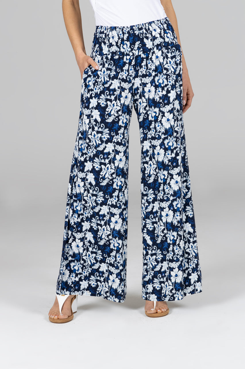 Woman wearing navy blue pants with white and blue floral print
