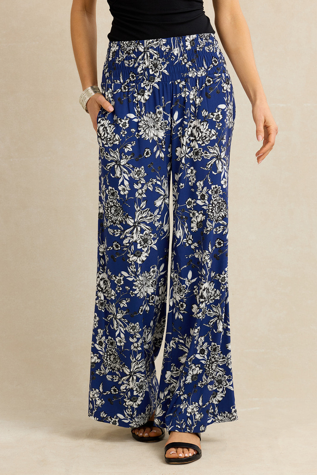 Blue floral-patterned pants worn by a person on a beige background
