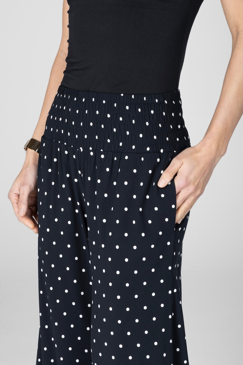 Close up of woman wearing black dot pants with smocked waistband