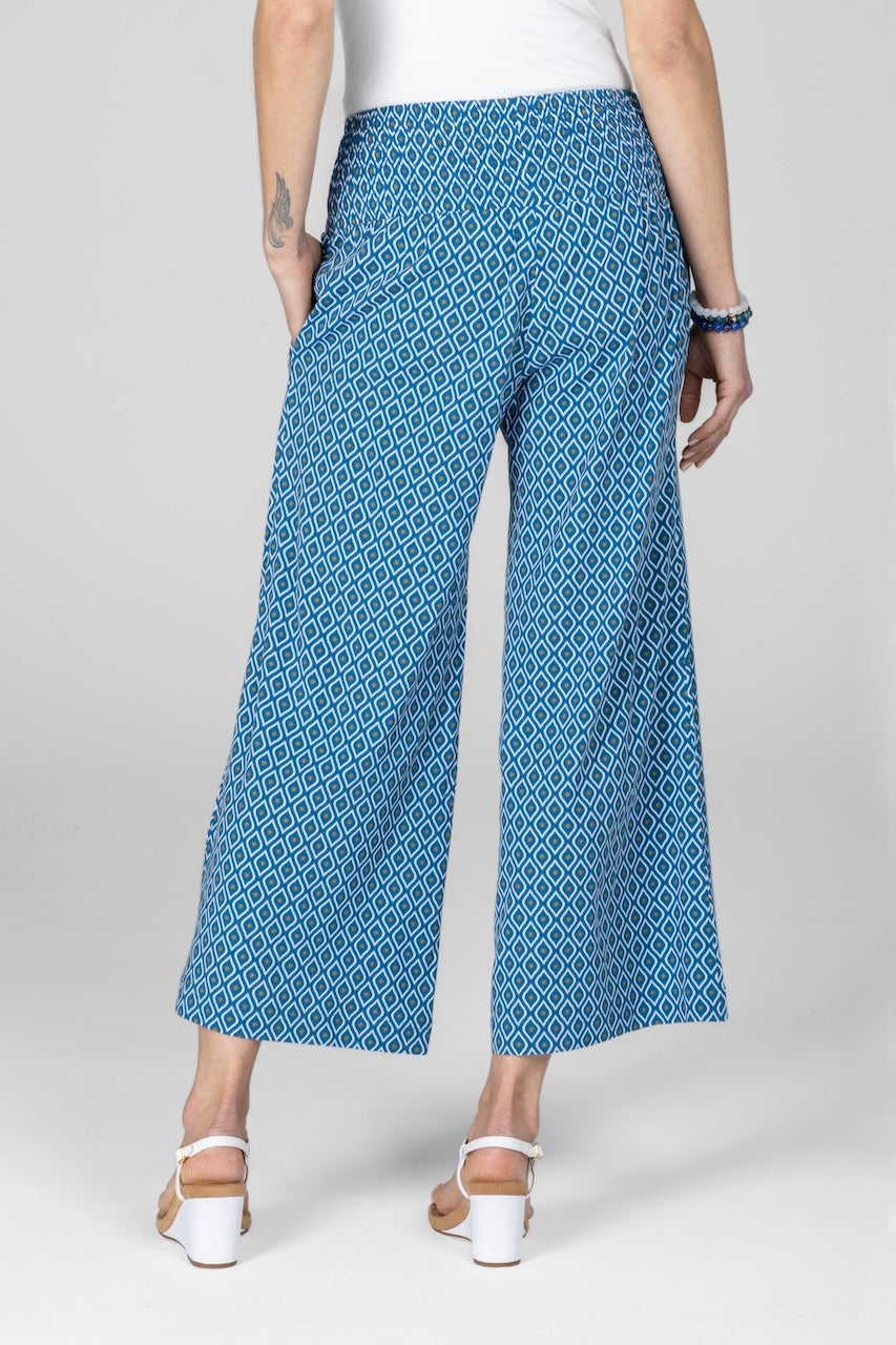 Back view of woman wearing blue ankle pants with geometric print