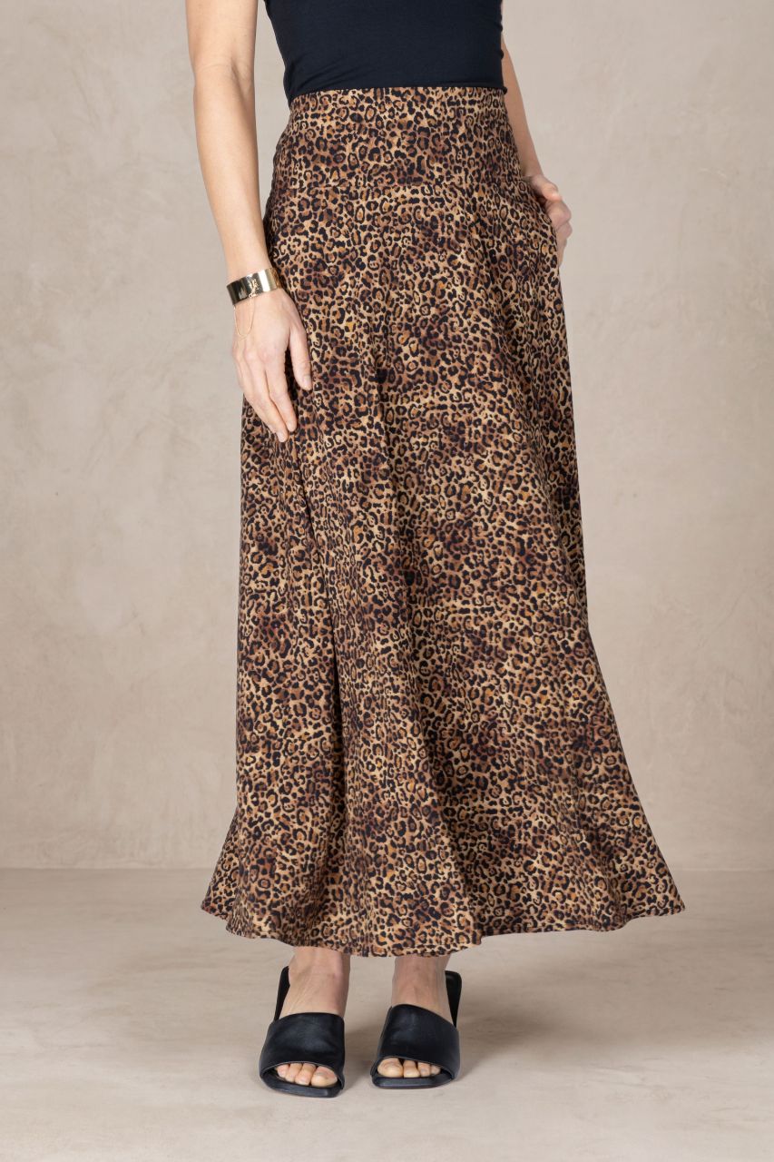 Person wearing a leopard print maxi skirt on a beige background
