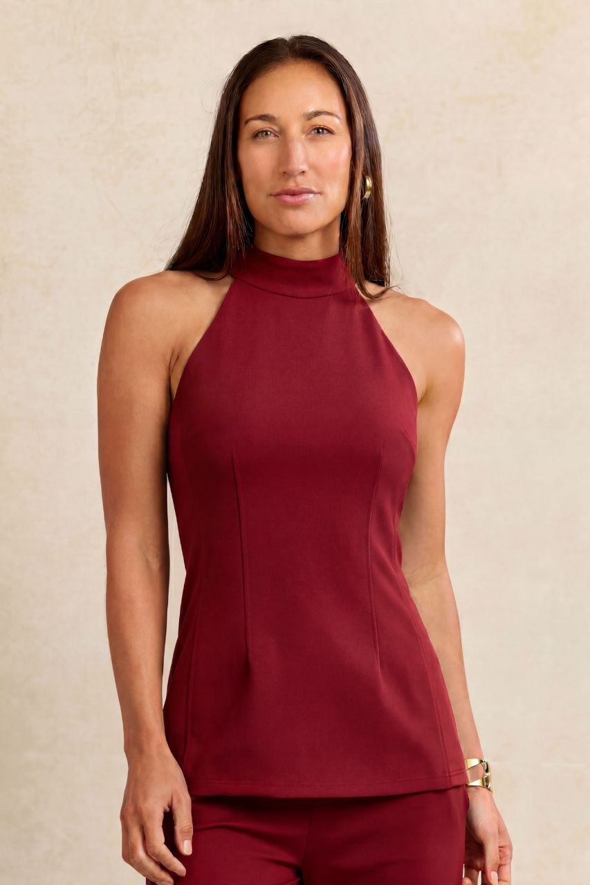 Woman wearing red halter top on a beige background