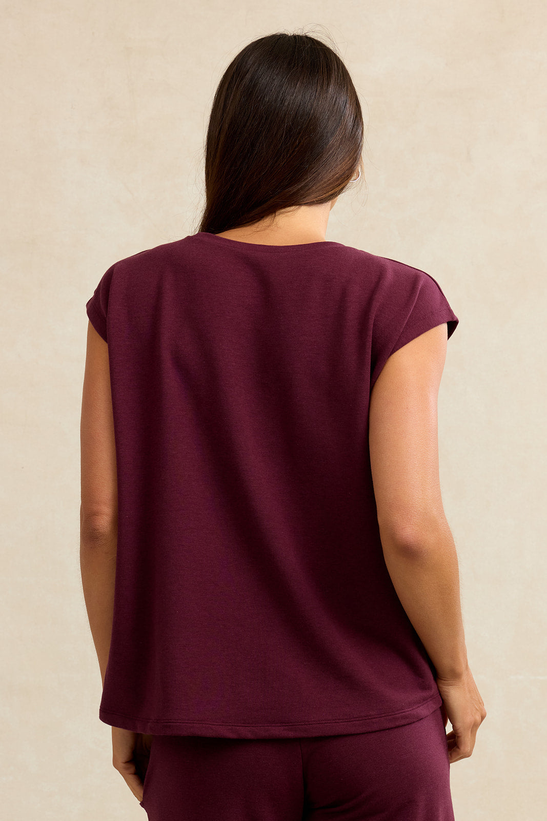 Back view of a woman wearing burgundy dolman shirt