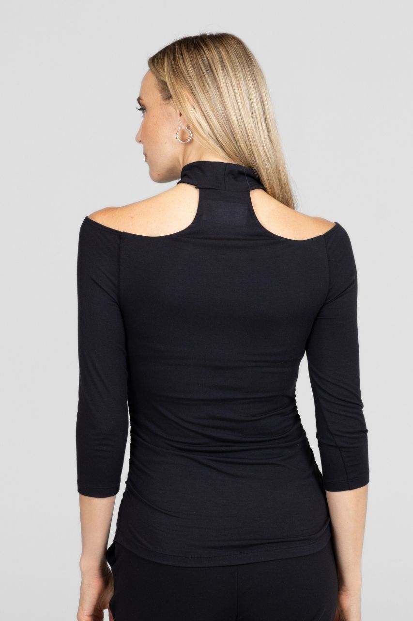 Back view of a woman wearing a black long-sleeve top with a mock neck collar on a gray background