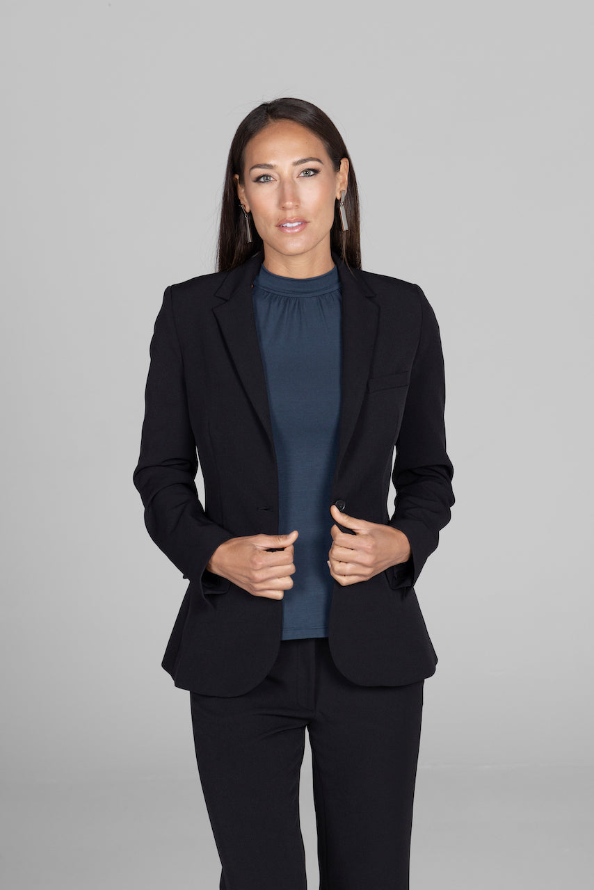 Woman wearing black blazer made of stretch woven fabric