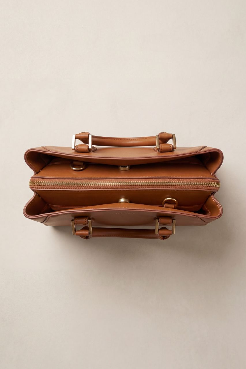 Brown PU leather handbag on a beige background