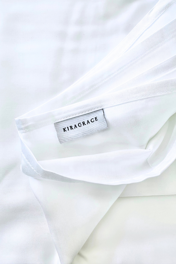 White bed sheets with KiraGrace logo