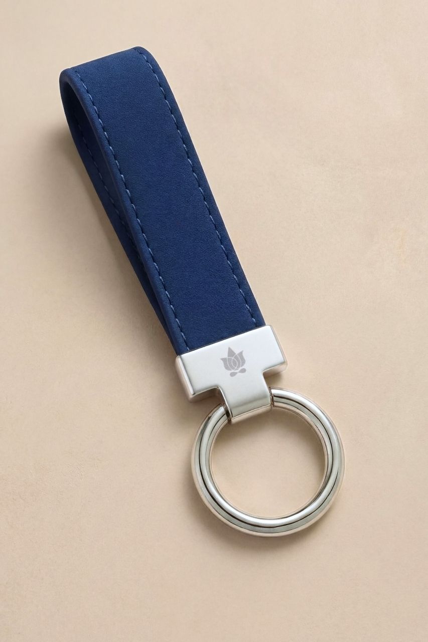 Navy blue KiraGrace Keychain on a beige background