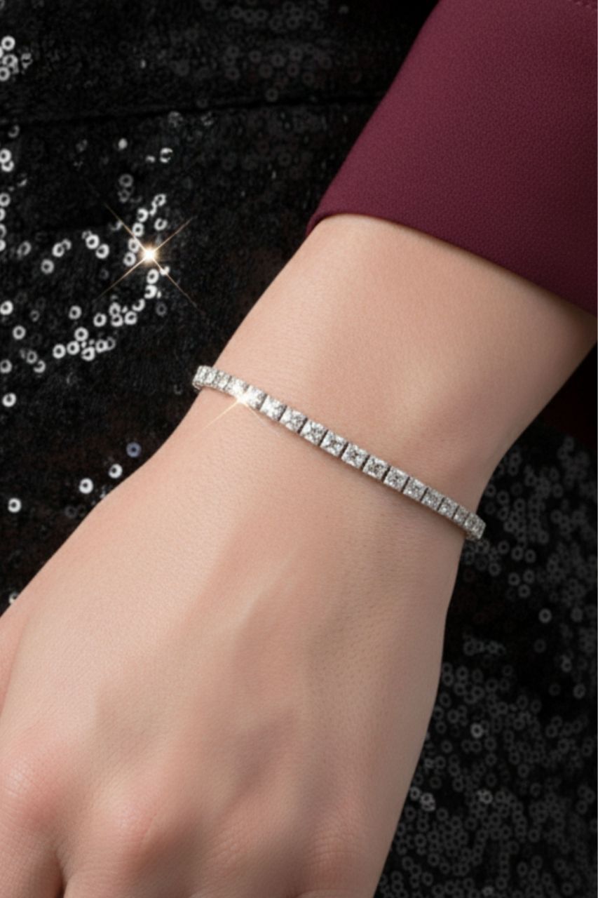 Silver bracelet on a wrist with a dark sequined pant background
