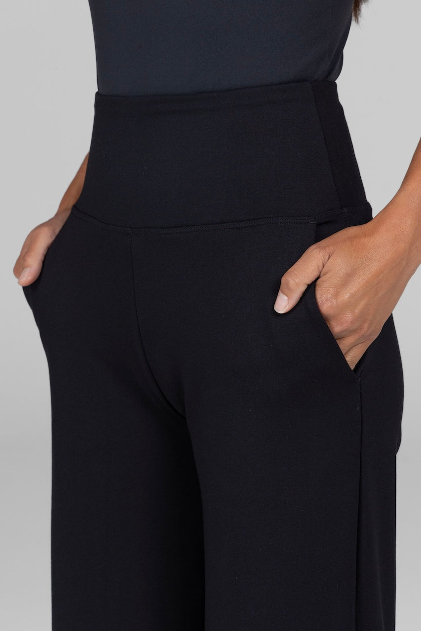 A close-up shot highlighting the pocket of the black high-waist, wide-leg ponte pants. The fabric looks durable yet flexible, providing both comfort and style.