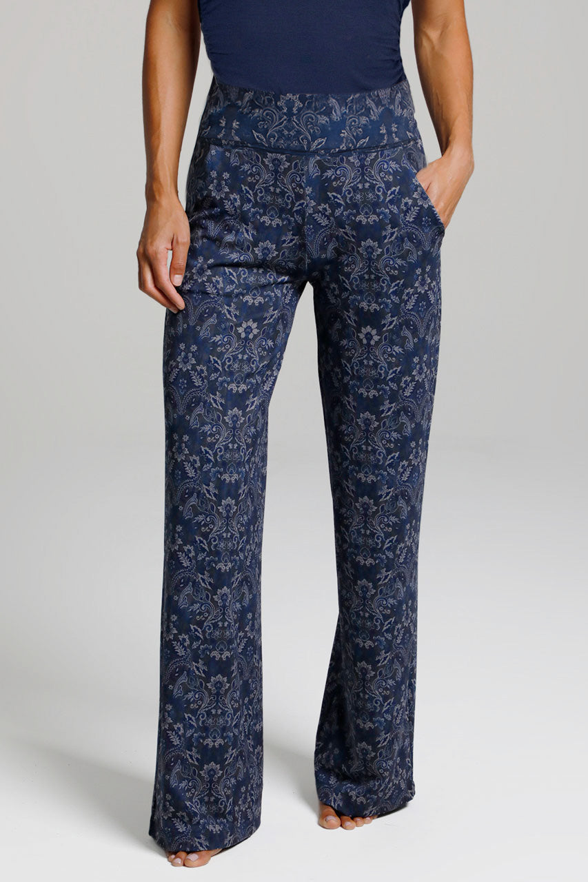 Woman wearing printed navy medallion high waist wide leg pants on a white background