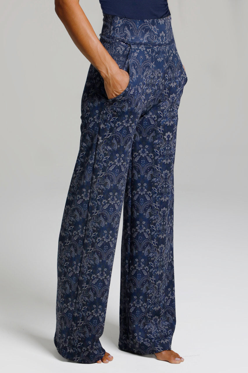 Woman wearing navy medallion wide leg pants on a white background