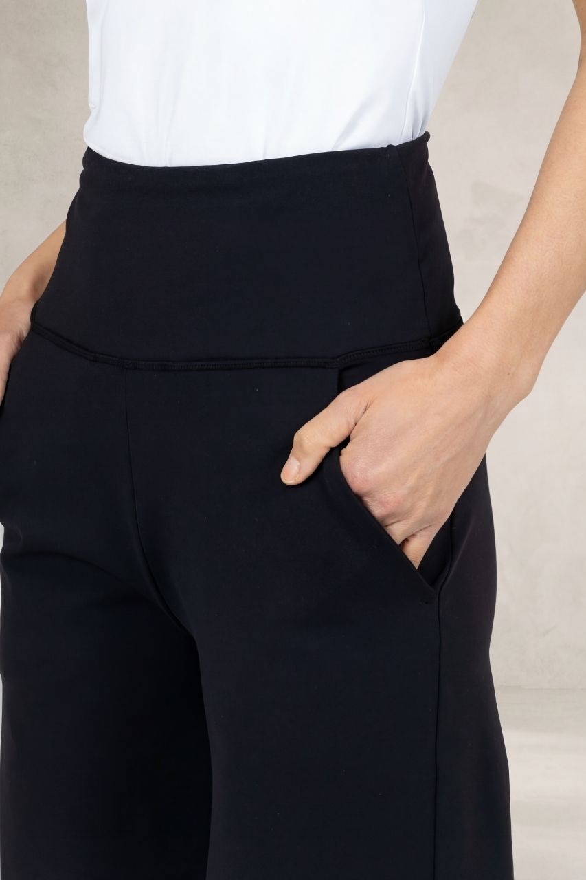 Close up view of a woman wearing black high waisted pants